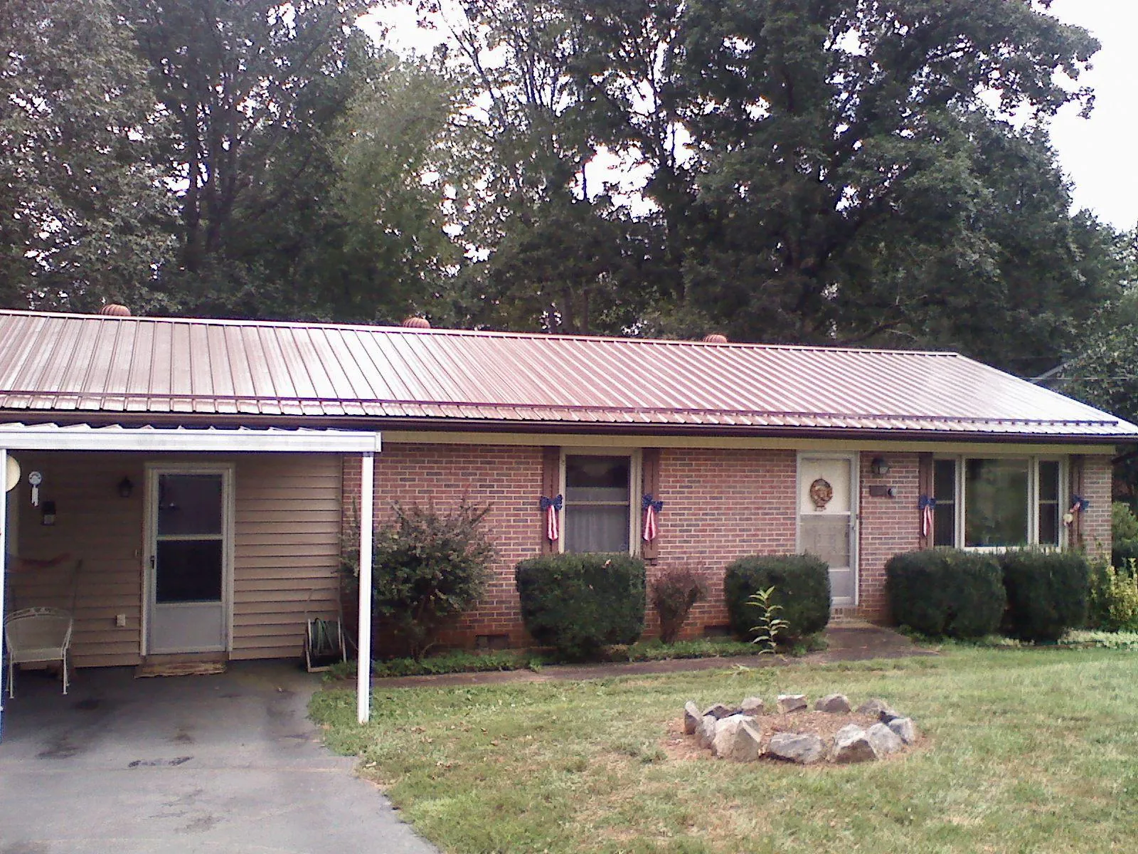 Bronze metal roof and carport on a brick ranch home — Roof Repair work by our crew in Birch River