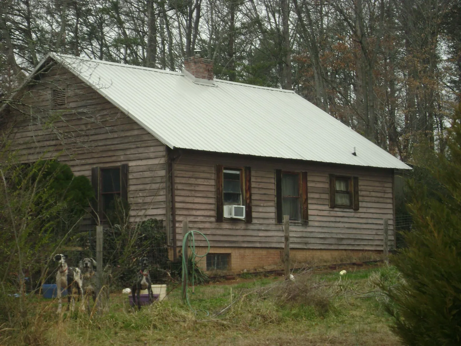 White metal roof on an old wood sided farmhouse, from a Metal Roof Installation job in Birch River